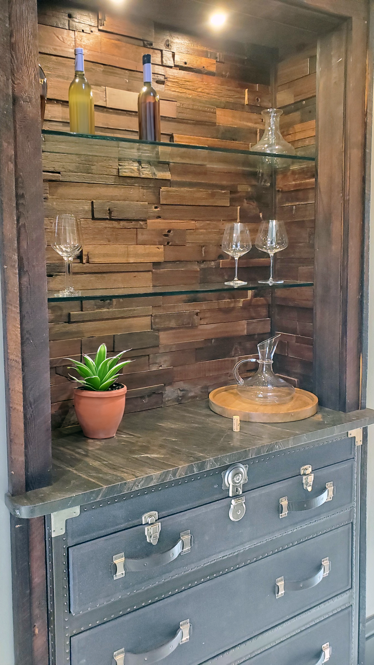 Custom reclaimed-wood bar with built-in glass shelving