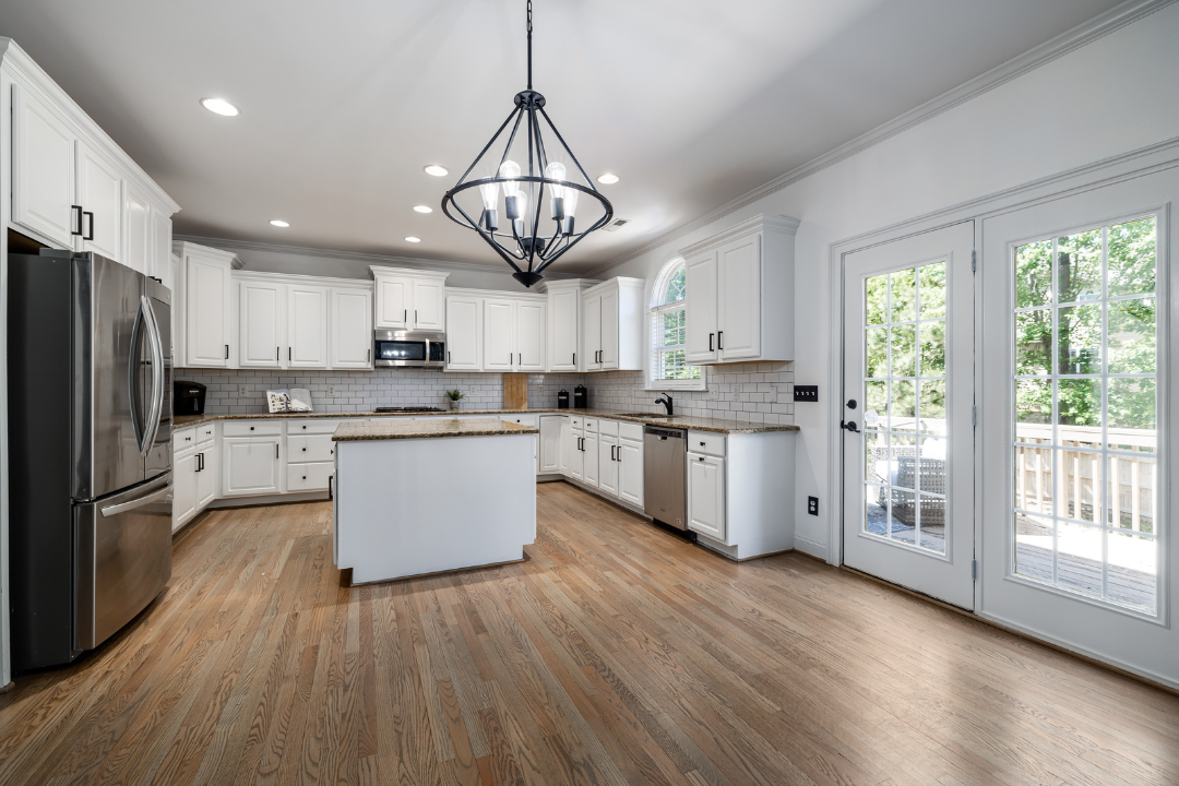 Open kitchen with hardwood flooring and french doors to a deck