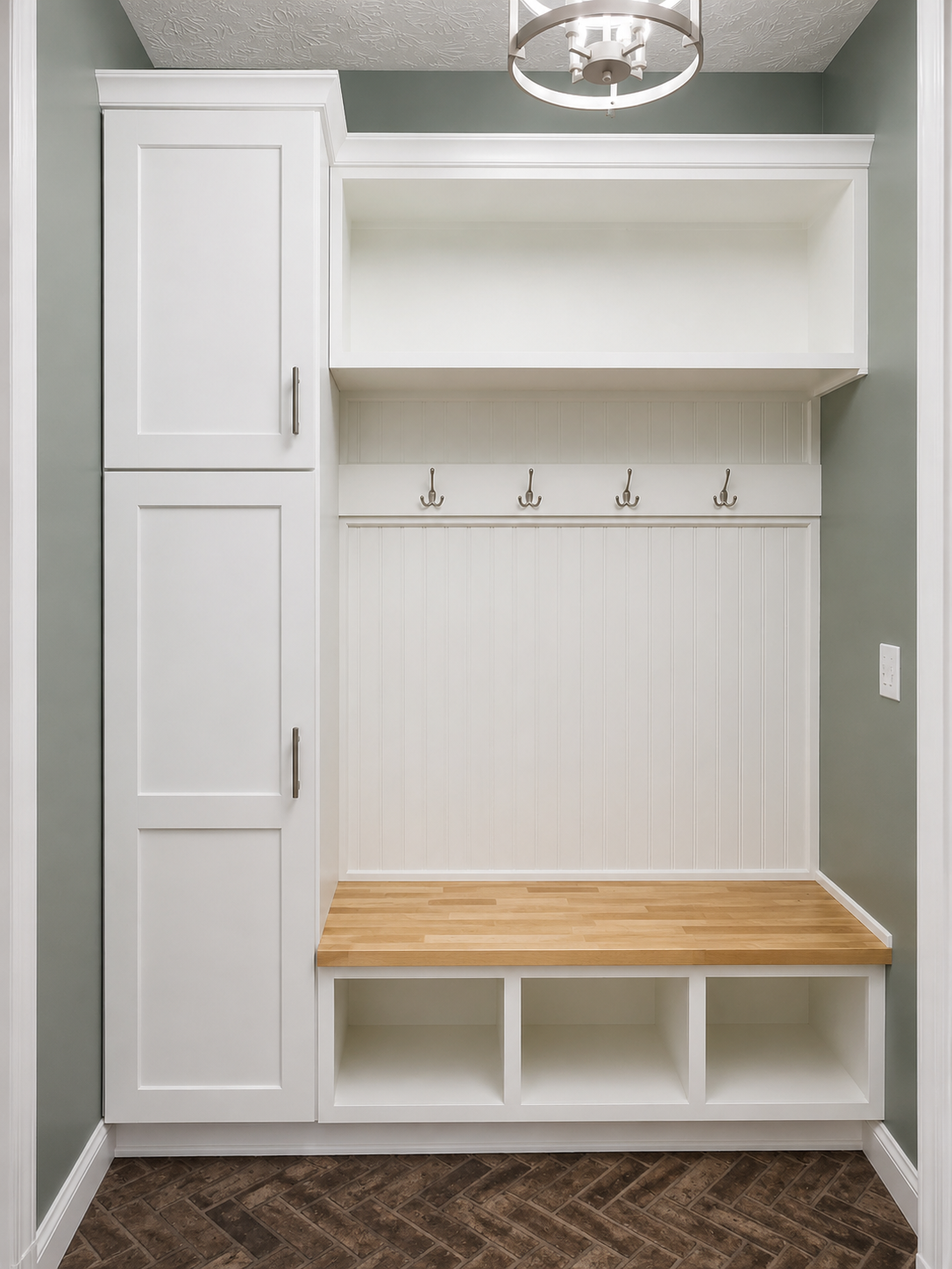 Custom mudroom built-ins with coat hooks, bench seat and herringbone brick floor